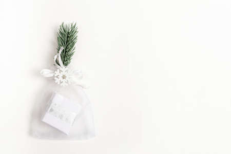 Xmas festive minimal backdrop with trendy Christmas small diy gift in mesh pouch and reusable decor...