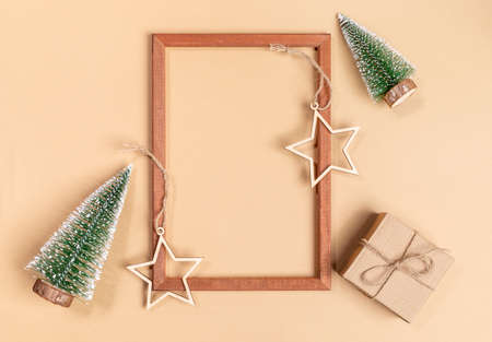 Christmas or New Year festive arrangement of empty wooden frame and wooden festive decorations -...