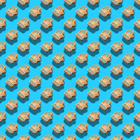 Christmas creative isometric with trendy shadows seamless pattern of festive gingerbreads as Santa's mittens on blue background. Xmas holiday decorations. Square photo.の写真素材