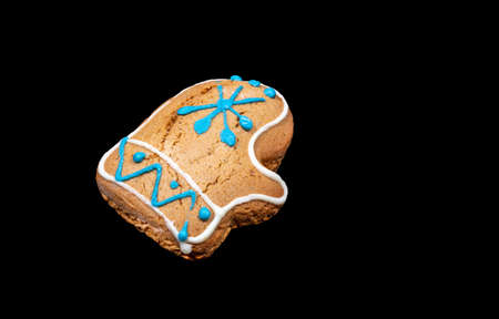 Christmas festive gingerbread as Santa's mitten close up on black background. Xmas holiday decorations. Horizontal orientation. Copy space for text.の写真素材
