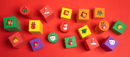 Festive banner with soft toys multicolored children's cubes with Xmas symbols above on them on red...