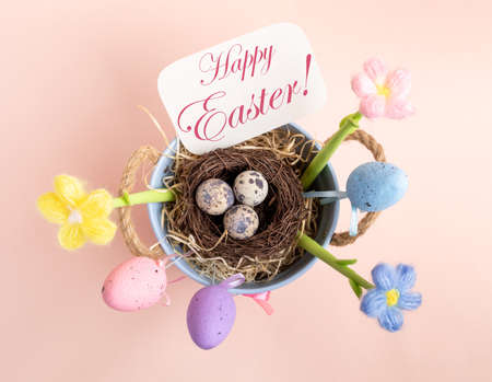 Easter card with decorations - nest of quail eggs, decorative color eggs, knitted flowers, note with...