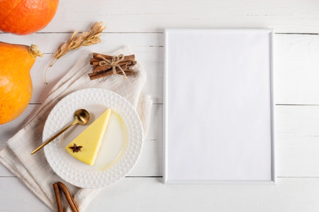 Autumn arrangement of pumpkin pie piece on white plate on napkin, pumpkins and empty frame for recipe or any of your text. Thanksgiving or Halloween holidays concept. top view. copyspace. Mock up.の写真素材