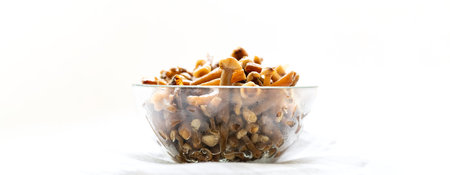 Wide banner with glass bowl of frozen forest mushrooms honey agarics on white background. Healthy...