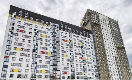 Modern residential buildings showcase colorful facades with a blend of contemporary architectural design elements, featuring large windows and unique patterns that enhance urban living aestheticsの写真素材