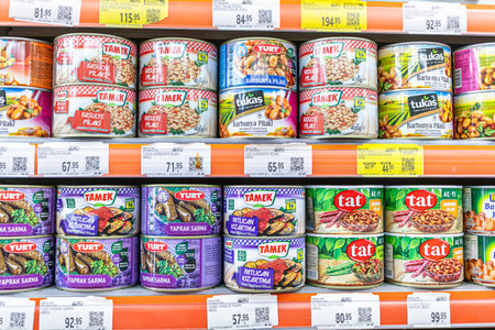 Incekum, Turkey - September 25, 2025: A variety of canned food products displayed on a supermarket shelf, featuring brands like Tamek and Tat, with colorful labels and price tags visible