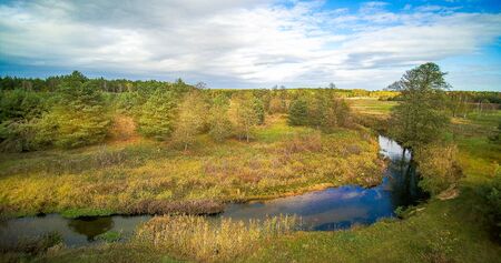 Small river in central Poland, flowing among green meadows and forests.の写真素材