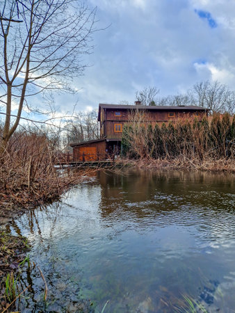 Old wooden house on the bank of a small river. Spring.の写真素材