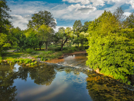 Beautiful spring landscape with a small river and trees in the parkの写真素材