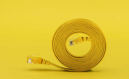 Coiled network cable on yellow background