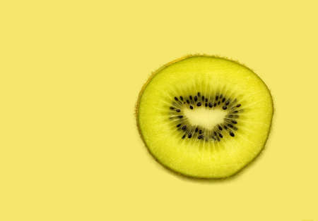 Macro photo of a kiwi slice isolated on kiwi backgroundの写真素材