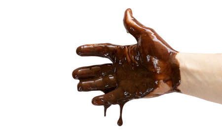 An open male hand dripping and spilling molten chocolate, white backgroundの写真素材