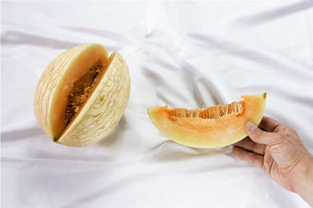 Waikiki Melon variety, cucumis melo hybrid fruit, white satin sheets backgroundの写真素材