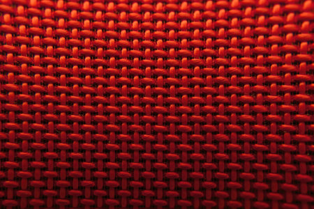 Texture of artificial industrial fabric of red color with a smooth black gradient, forming an...