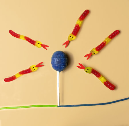 candies in the shape of snakes looking for the sugar of a lollipop, concept of prediabetes, sugar...