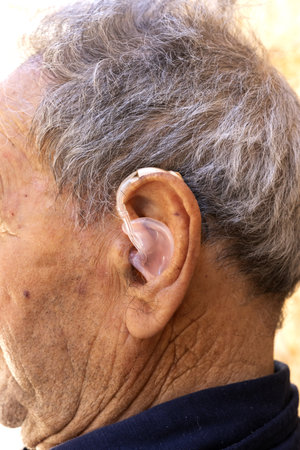 Elderly Man Wearing Hearing Aid â€“ Close-Up Profile View