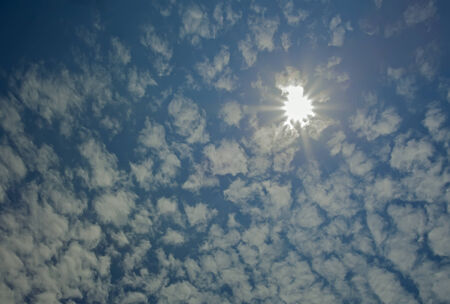 White clouds in blue sky and sun 