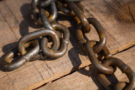 Rusty chain on the wooden groundの写真素材