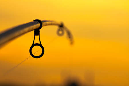 Fishing rod on the orange backgroundの写真素材