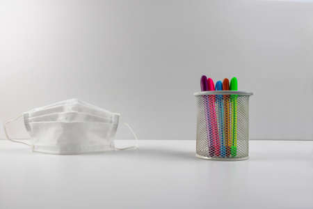 pens in the pen box and a face mask in new normalの写真素材