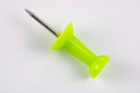 a green push pin in focus