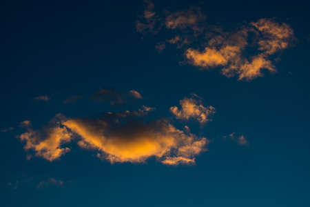 Orange and gray clouds on the sky at sunsetの写真素材