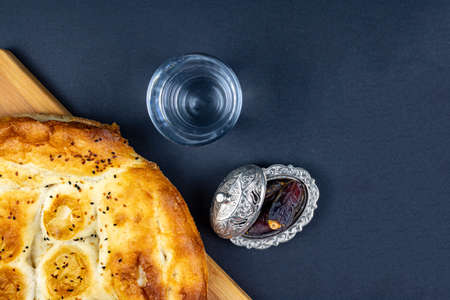 Traditional Ramadan Pita, a glass of water and dates from top. Iftar foods. Ramadan fast. Ramadan and iftar background photo. Traditional Turkish ramadan foods Ramadan pita.の写真素材