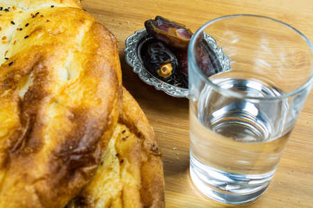Traditional Ramadan Pita, a glass of water and dates from top. Iftar foods. Ramadan fast. Ramadan...
