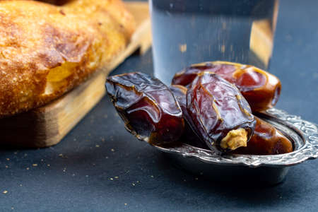 Traditional Ramadan Pita, a glass of water and dates from top. Iftar foods. Ramadan fast. Ramadan and iftar background photo. Traditional Turkish ramadan foods Ramadan pita.の写真素材
