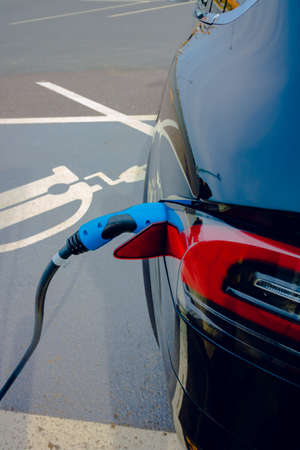 Plugged in Fast EV Charger to the EV car in focus