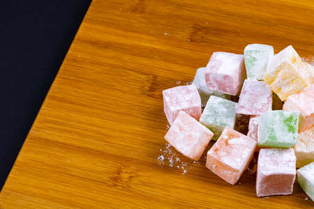 Turkish Delights on the wooden plate isolated on black background. Eid al-Fitr (eid al fitr) and Eid al-Adha (eid al adha) background photo. Turkish delight (Turkish delight). Eid mubarak - happy holidaysの写真素材