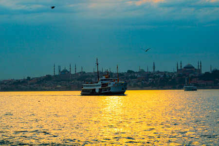 Istanbul city lines ferry and cityscape of Istanbul at sunset.の写真素材