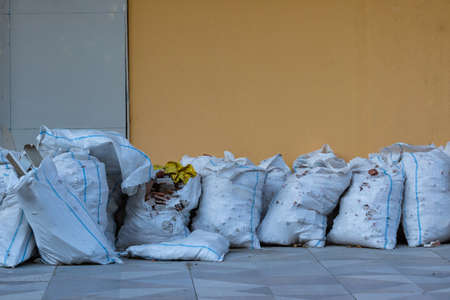 White plastic sacks full of rubbles on the street. construction waste. Renovation waste. Pollution