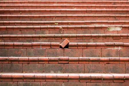 A displaced brick on the stairs. Being different, exclusion, incompatible concept.の写真素材