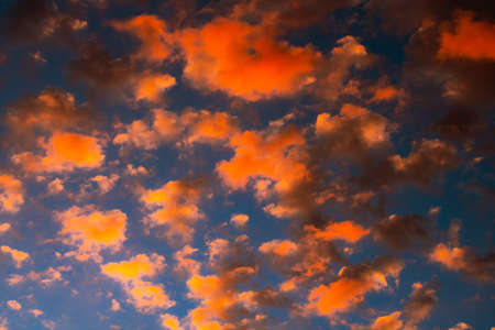Dramatic orange clouds at sunset. Cloudscape abstract background photo.