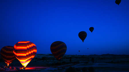 Hot air balloon's preparation for taking off at sunrise in Cappadocia. Hot air balloon tour in Cappadocia Turkey. Tourism in Turkey.の写真素材