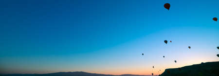 Hot air balloons at sunrise. Banner of hot air balloons on the sky in cappadocia. Travel or tourism in turkey background photo.の写真素材