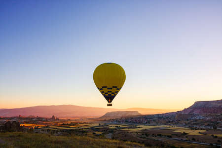 Yellow hot air balloon. Single hot air balloon in Cappadocia at sunrise. Cappadocia background photo. noise effect.の写真素材