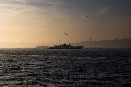 Moody Istanbul background. Silhouette of ferry and cityscape of Istanbul. Galata tower and mosques.