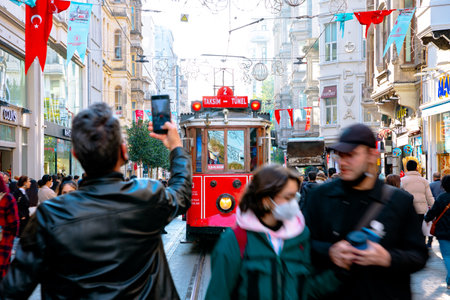 Istiklal Avenue. Tourist taking a photo of nostalgic tram in Istiklal Street. Istanbul background photo. Travel to Turkey. Istanbul Turkey - 11.13.2021のeditorial素材
