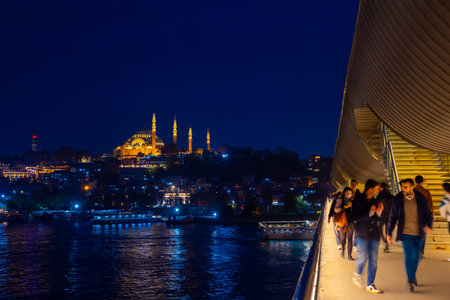 Istanbul at night. People walking on the Golden Horn Metro Bridge. Suleymaniye Mosque on the background. Turkey or istanbul or ramadan background photo. Istanbul Turkey - 10.15.2021のeditorial素材