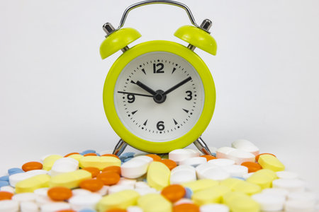 Alarm clock with pills. Using medicines in right time concept photo. Using medical drugs or...