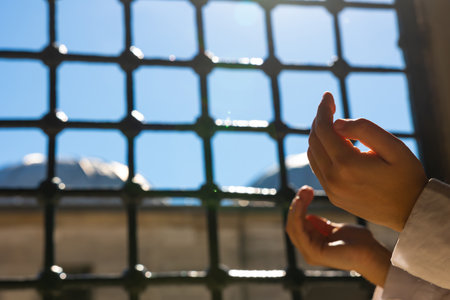 Islamic or ramadan concept. Muslim woman praying with raising hands. Kandil or laylat al-qadr or kadir gecesi background photo.の写真素材