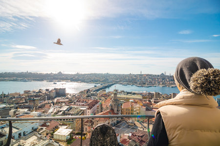 Visit Istanbul concept photo. A tourist on the balcony of Galata Tower and cityscape of Istanbul on the background.の写真素材