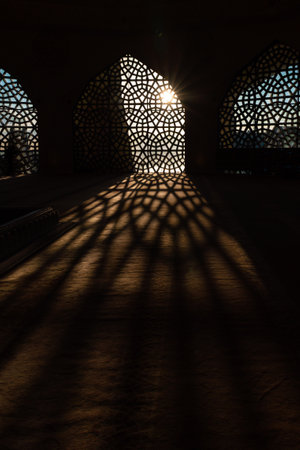 Islamic vertical concept photo. Islamic pattern on the window and shadows on the ground. Ramadan or...