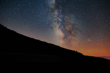 Starry night and silhouette of the hills. The Milky Way background photo.