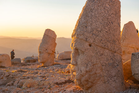 Zeus or Oromasdes statue in Mount Nemrut at sunset. Statue of Apollo in the background.の写真素材