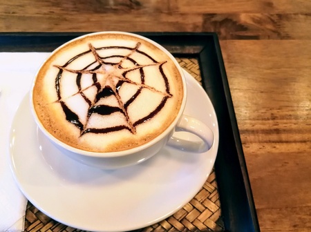 A cup of hot mocha coffee in white cup on the wooden table.の素材