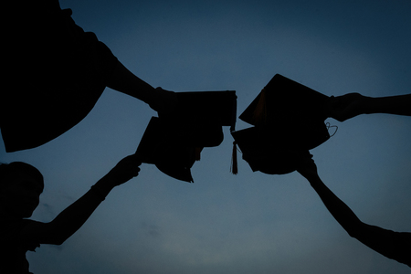 Female university graduate celebrates graduation ceremony receiving degree certificate happily with excitement.の写真素材