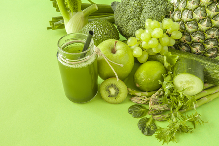 Green health smoothie fruits and vegetables, kale leaves, lime, apple, kiwi, grapes, banana, avocado, lettuce pineapple salat. Copy space. Raw, vegan, vegetarian, alkaline food concept.の写真素材